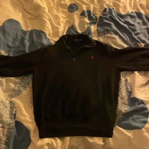 Half zip tröja Polo Ralph Lauren - Säljer en stilren svart tröja från Polo Ralph Lauren med en liten röd logotyp på bröstet. Tröjan har en halv dragkedja och ribbade muddar vid ärmslut och nederkant. Säljer den för jag aldrig använder den. Pris kan diskuteras vid snabb affär👍. Strolek Xl men skulle säga att den passar mer som en L 