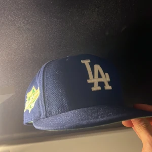 Blå keps från New Era -  keps från New Era LA och en broderad World Series-märke på sidan. Kepsen har en klassisk passform och MLB-logga framme!