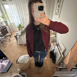 Vinröd bomberjacka - Snygg vinröd bomberjacka med dragkedja framtill. Perfekt för en casual look och passar bra till jeans. Jackan har långa ärmar och en stilren design. Den är så snygg och cool men har för många jackor😭🩷