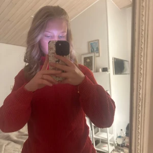 Röd stickad tröja - Säljer en mysig röd stickad tröja med långa ärmar. Perfekt för kyligare dagar och ger en varm känsla. Passar bra till både jeans och kjol.