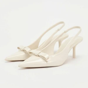 Vita klackar med rosett - Vita klackar med spetsig tå med rosett på. Passar perfekt till student eller till sommarn. Aldrig använda, skulle ha till studenten men valde ett par andra! Nypris 399kr