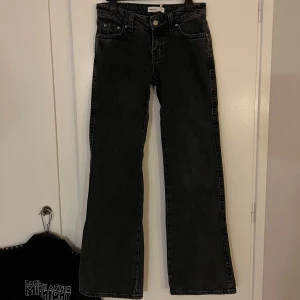 Snygga lågmidjade bootcut/flared jeans - Lågmidjade bootcut/flared jeans (Y2K Offblack) från Gina Tricot, original pris 499kr. Säljer dom då jag råkade beställa fel storlek och dom tyvärr var för små för mig. Har du några frågor så får du absolut skicka iväg ett meddelande! :) OBS! Katt finns i hemmet!