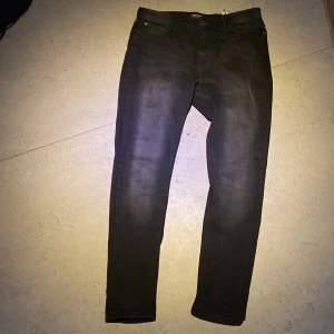 Svarta jeansbyxor - Snygga svarta jeansbyxor med en straight passform. De har klassiska fem fickor och en knappgylf. Perfekta för en stilren look.