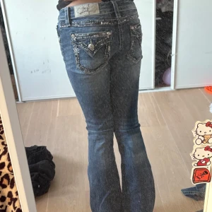 Blå  Miss Me jeans  - Snygga blå bootcut jeans från Miss Me med låg midja. Nya modellen , storlek 25 bakfickor med broderade detaljer .