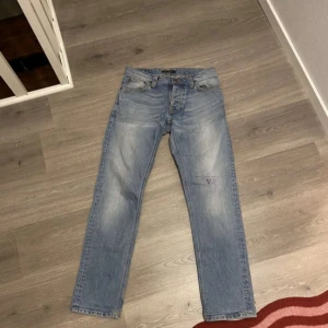 Blå jeans från Replay - Snygga blå jeans från Replay med en klassisk straight fit. De har en lätt tvättad look och femficksdesign. Perfekta för en avslappnad stil. Se sista bild för litet märke
