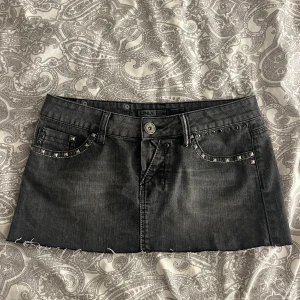 Svart lågmidjad mini jeanskjol  - Söt svart lågmidjad jeanskjol från ONLY med nitar och slitna detaljer. Midjemått: 38cm. Storlek W28. Skriv för fler frågor eller bilder💗