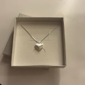 Silverhalsband med hjärthänge - Elegant silverhalsband med ett hjärtformat hänge. Perfekt för att ge en subtil och stilren touch till din outfit. Kedjan är tunn och smidig, vilket gör den bekväm att bära.