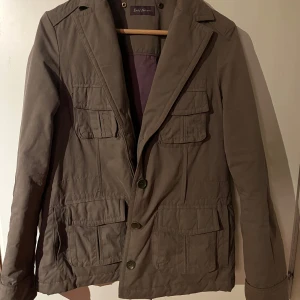 Brun jacka från Zadig & Voltaire - Säljer en snygg brun jacka från Zadig & Voltaire. Jackan har en klassisk design med knappar framtill och flera praktiska fickor. Perfekt för en stilren look.