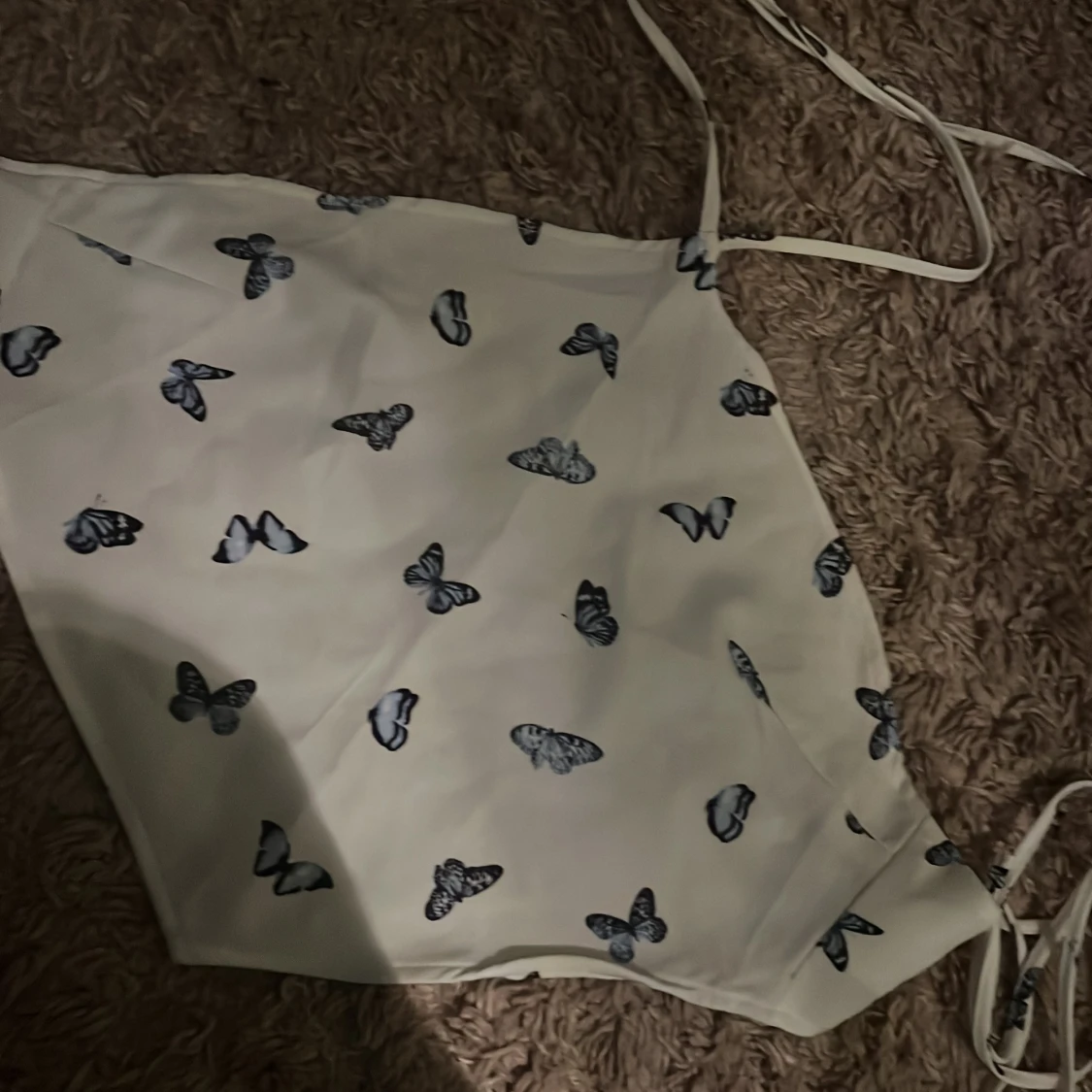 Vit topp med fjärilsmönster