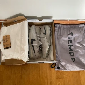 Nike Tiempo Legend 10 Elite FG Rising Gem - Nike Tiempo Legend 10 Elite FG Rising Gem. These Nike tiempos are in really good shape and only worn a little bit. They are soft but at the same time they’ve got some really nice grip and precision. The condition is 8/10 because they are a little bit dirty but that will probably just wash away. They are also a bit damaged in the front but nothing serious. Otherwise are they in perfect shape. Size: 42,5. Shipping: I will ship the same day you order. THE SHOES COMES WITH THE ELITE BAG AND THE BOX.