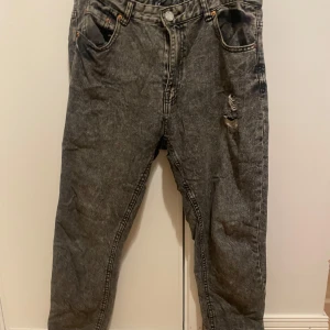 Grå jeans  - Fina gråa jeans köpte dom med hål i där det där bak ska vara så och det är hål i fickan. Har klippt bort lappen