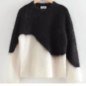 Svart och vit stickad tröja från other stories - Säljer en mysig stickad tröja från & other stories i svart och vitt. Tröjan har en unik diagonal design och långa ärmar. Säljer då den inte kommer till användning så mycket❤️skriv vid frågor och funderingar!