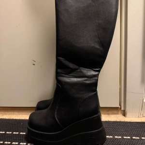 Svarta stövlar - Snygga svarta stövlar med hög platåsula. Perfekta för att ge lite extra höjd och stil till din outfit. De har en enkel och elegant design som passar till många olika tillfällen.