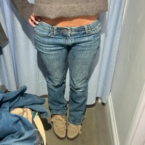 Blå jeans med låg midja - Snygga blå jeans med låg midja och klassisk femficksdesign. De har en straight passform och är perfekta för en avslappnad stil.  Mina gamla favorit jeans som inte längre används, några små defekter som det brukar bli längst ner, midjemått är 39/40 och innerbenslängd cirka 80🩷