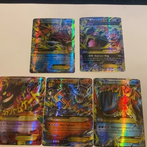 Pokémonkort Mega Evolution - Säljer en samling av fem Pokémonkort med Mega Evolution-tema. Inkluderar M Gyarados, M Tyranitar, M Gengar, M Charizard och M Swampert. Korten har en holografisk yta och är perfekta för samlare eller spelare som vill förstärka sin kortlek.