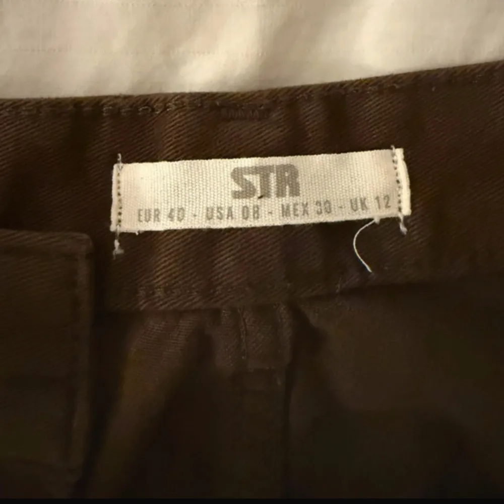 Säljer ett par bruna cargobyxor från Stradivarius. Byxorna har flera praktiska fickor och en bekväm passform. Perfekta för en avslappnad stil.. Farkut & Housut.
