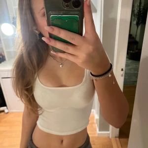 Vit croppad T-shirt  - Säljer en stilren vit croppad linnetopp med rund halsringning. Perfekt för varma dagar eller som ett basplagg i garderoben. I storlek xxs men passar xs