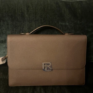 RL väska  - Väska av kornigt läder med axelrem. Väskan är limiterad och inkludera originalförpackningen. Den är aldrig använd med taggar. 