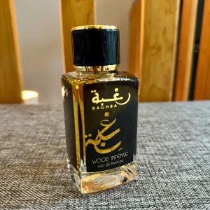 Raghba Wood Intense Eau de Parfum - Raghba Wood Intense från Lattafa är en Eau de Parfum för män med en rik och träig doftprofil. Flaskan är elegant med en svart och guld etikett, vilket ger en lyxig känsla. Doften har noter av trä, amber, och sötma, med inslag av rökighet och vanilj. Endast testad. Förpackning saknas.
