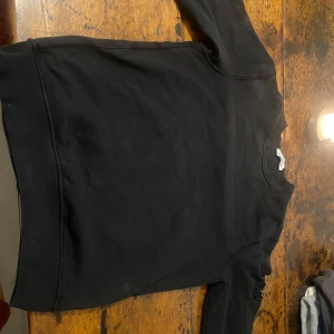 Svart tröja från Stone Island - Säljer en stilren svart tröja från Stone Island. Tröjan har långa ärmar och ett ikoniskt märke på ärmen. Perfekt för en casual look. Passar xs-s
