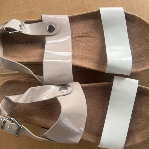 Beige och vita sandaler från Graceland - Snygga sandaler från Graceland i beige och vitt med justerbart spänne. Perfekta för sommardagar med en stilren design och bekväm passform.