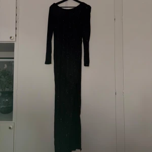 Svart glittrig långklänning - Svart glittrig långklänning💖 klänningen akutköptes till nyår, men användes aldrig🥰🥰 den har en slits fram och är v-ringad i ryggen. Hör av dig om du har några frågor💖märket är Nelly Eve och är i storlek 36, priset kan diskuteras vid snabb affär