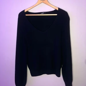 Marinblå tröja från holebrook - Snygg svart ribbad tröja från Pull&Bear med v-ringning. Perfekt för en stilren look. Tröjan har långa ärmar och en bekväm passform. Ett måste i garderoben för alla modeälskare!