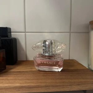 Versace Bright Crystal Eau de Toilette - Säljer en Versace Bright Crystal Eau de Toilette 50ml. Flaskan har en lyxig design med en stor, kristalliknande kork. Den har en fräsch och feminin doft. (Parfymen är nästan full, endast tagit några sprut)