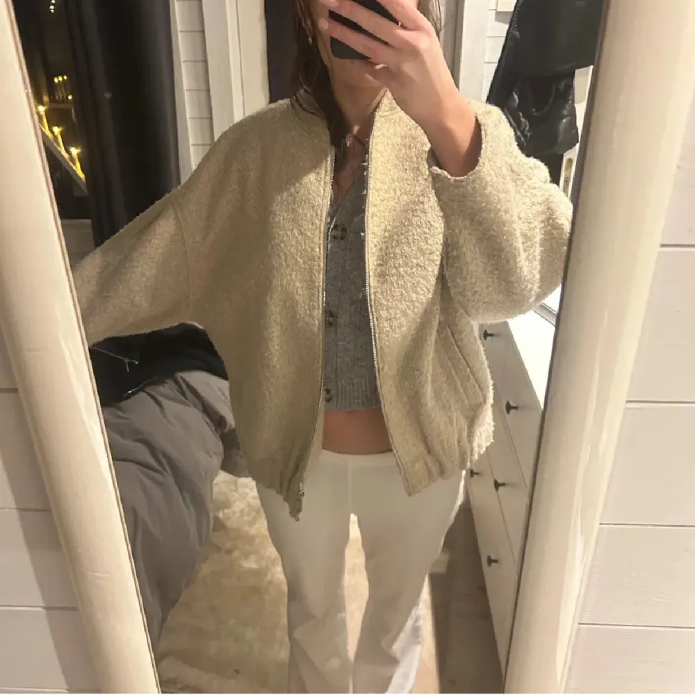 Mysig beige teddyjacka med dragkedja framtill. Jackan har en loose passform och långa ärmar, perfekt för kyligare dagar. Den är enkel att matcha med olika outfits och ger en avslappnad look.. Takit.