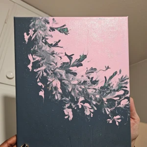 Abstrakt konstverk på duk - Säljer ett unikt abstrakt konstverk på duk med en vacker kombination av rosa och mörkgrå färger. Målningen har ett blommigt mönster som ger en känsla av rörelse och elegans. Perfekt för att ge liv åt vilket rum som helst. 🎨