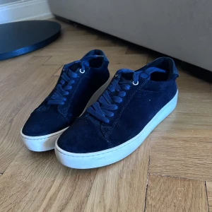 Vagabond Zoe - Snygga marinblåa sneakers i mocka från Vagabond i mocka med vita sulor. Skorna har snörning och en stilren design som passar perfekt till vardags. De är bekväma och lätta att matcha med olika outfits. Snörena är även utbytta därav helt nya och fräscha - bara skriva om det är något man undrar. Nypris: 1100kr