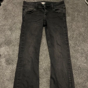 Svarta jeans från Gina Tricot - Snygga svarta jeans från Gina Tricot med bootcut-stil. De har en klassisk femficksdesign med knappar på bakfickorna. Perfekta för en stilren look. Storlek 152 i mycket bra skick.