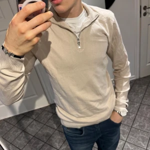 Beige tröja med dragkedja - Säljer denna snygga halv zip stickade tröjan från only & sons i mycket bra skick. Den är knappast använd och i storlek S. Materialet är väldigt stretchigt och skönt. Kom gärna med prisförslag!!