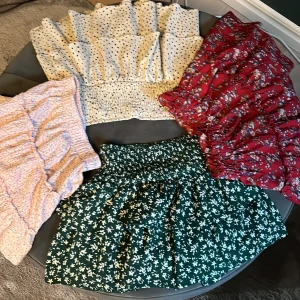 Fyra  mönstrade volangkjolar - Säljer flera kjolar i olika mönster och färger. En vit prickig kjol med volanger, en röd blommig kjol, en grön blommig kjol och en ljusrosa kjol med volanger. Perfekta för att liva upp garderoben! Tre från Zara i och en från Shein. Supersöta och knappt använda! Stl 140.