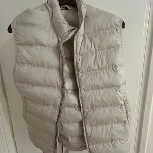 Beige dunväst från Zara - Helt ny oanvänd  beige dunväst från Zara med dragkedja framtill. Perfekt för lager-på-lager under kyliga dagar. Storlek M 