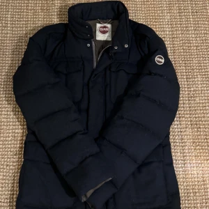 Svart pufferjacka från Colmar - Säljer en svart pufferjacka från Colmar. Jackan är quiltad och perfekt för kyligare väder. Den har en stilren look med Colmar-logga på ärmen.