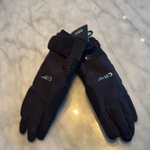 Svarta CRW rid handskar - Snygga svarta handskar från CRW, perfekta för ridning. De har en stilren design med greppvänlig yta och justerbar stängning vid handleden. Passar ungdomar i åldern 11-13 år.