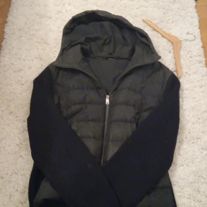 Svart cardigan jacka från Jil Sander - Snygg svart jacka från Jil Sander med huva och dragkedja. Jackan har en quiltad design och är perfekt för kyligare dagar. Den är stilren och passar bra till olika outfits.