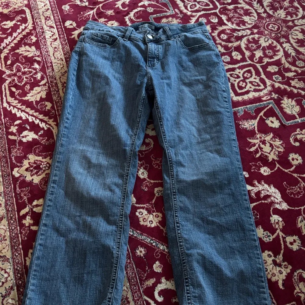 Säljer ett par klassiska blå jeansbyxor med rak passform. Byxorna har en traditionell femficksdesign och är perfekta för en avslappnad stil. De är tillverkade i ett slitstarkt denimtyg.. Farkut & Housut.