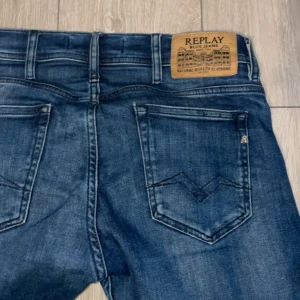 Blå jeans från Replay - Snygga blå jeans från Replay med klassisk femficksdesign och en diskret logga på bakfickan. Jeansen har en modern passform och är perfekta för en avslappnad stil. De har en knappgylf och är tillverkade i ett slitstarkt denimtyg.