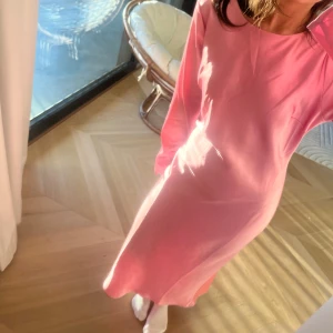 Rosa långklänning med öppen rygg - Storlek M men sitter som S. Säljer min rosa långklänning med öppen rygg och knytband från Ginatricot😍säljer då den inte kommit till användning. Klänningen har några difekter  men inget som syns jätte tydligt