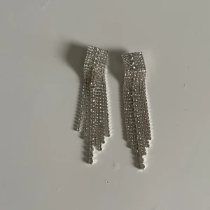 Silvriga örhängen - Säljer ett par örhängen som spänns på örat. Perfekt för de som inte har hål i öronen, örhängena har inte används. 