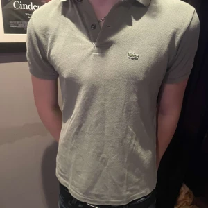 Grön pikétröja från Lacoste - Säljer en fet grön pikétröja från Lacoste med klassisk krage och knappar. Började bli för liten men det är ett bra plagg med bra kvalitet och jag hoppas att det kan återvändas 😁