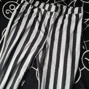 Svartvita randiga byxor - Snygga svartvita randiga byxor med hög midja och bootcut-stil. De har en elastisk midja för extra komfort. Nya och oanvända! 