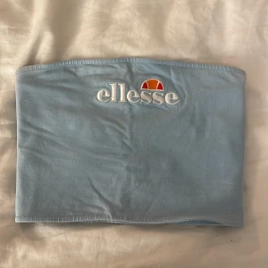 Ljusblå tubtopp från Ellesse - Säljer en ljusblå tubtopp från Ellesse med broderad logga framtill. Perfekt för varma dagar och enkel att matcha med olika outfits. Tillverkad i ett mjukt och bekvämt material. Passar som en 38!❣️