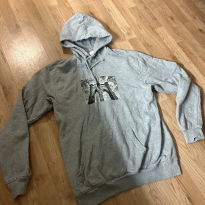 Grå Hoodie Med Tryck - Säljer denna stilrena hoodie ifrån ”Vailent”. Tröjan är i jätte bra skick och har ett snyggt tryck mitt på bröstet. Storlek: M. Skriv vid funderingar så löser vi en bra deal