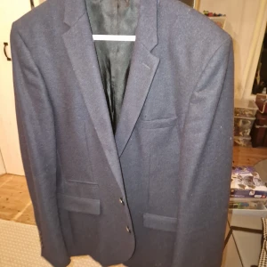 Svart kavaj från Selected Homme - Snygg mörkblå kavaj från Selected Homme. Klassisk design med två knappar framtill och fickor. Perfekt för en stilren look.