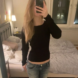 Svart ribbad tröja med öppen rygg - Svart ribbad tröja med långärmad design och öppen ryggdetalj. Aldrig använd men saknar prislapp🤍