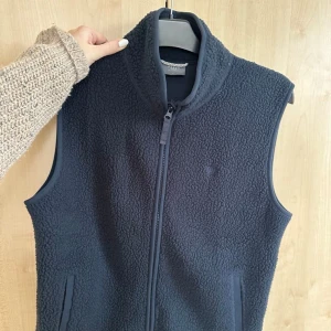 Mörkblå fleeceväst från Ullmax - Säljer en mörkblå fleeceväst från Ullmax i storlek M. Västen har en tvåvägs- dragkedja framtill och är perfekt för kyligare dagar. Den är mjuk och bekväm att bära.