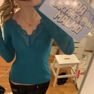 Intimissimi tröja med spets - Säljer en snygg och trendig turkos långärmad topp med v-ringad spetsdetalj. Färgen säljs inte längre vilket gör den extra unik. Perfekt för att lägga till en färgklick i garderoben. Passar bra till både jeans och kjol.